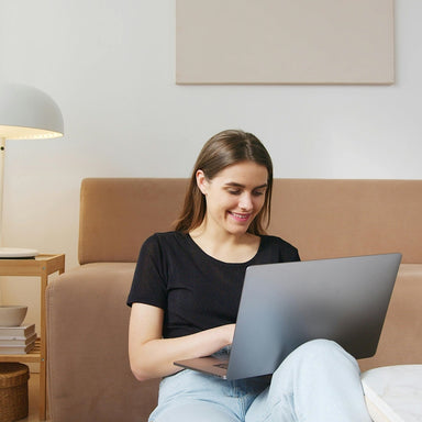 Person sitting in living room on a laptop studying